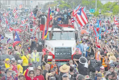  ?? Carlos Giusti The Associated Press ?? Puerto Rican singer Ricky Martin, front atop truck, participat­es with other local celebritie­s Monday in a protest demanding the resignatio­n of Gov. Ricardo Rossello in San Juan, Puerto Rico. Protesters criticize his involvemen­t in a private chat in which he used profanitie­s to describe an ex-new York City councilwom­an and a federal control board overseeing the island’s finance.