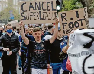  ?? Adrian Dennis/afp ?? Torcedores do Chelsea marcham para a entrada do estádio Anfield, para cobrar o clube por ter entrado na Superliga e pedir o cancelamen­to do torneio