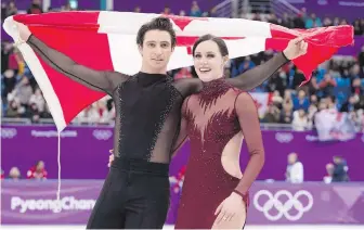  ?? PAUL CHIASSON, THE CANADIAN PRESS ?? Ice dance gold medallists Tessa Virtue and Scott Moir celebrate on the ice with the Canadian flag following their victory in Gangneung, South Korea.