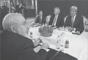  ?? Associated Press ?? Talks continue: Iran’s Foreign Minister Javad Zarif, foreground, holds a bilateral meeting with U.S. Secretary of State John Kerry, background right, on the second straight day of talks, in Vienna, Austria, on Monday. Kerry continued in-depth...