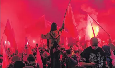  ?? PHOTO: GETTY IMAGES ?? Right sees red . . . People hold red flares and a Polish National flag during the Independen­ce day march organised by rightwing groups on the 102nd anniversar­y of Poland's independen­ce day yesterday in Warsaw.