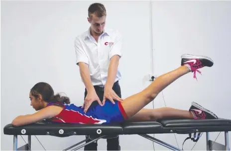  ??  ?? Physiother­apist Alex Beck uses a lower body testing component on Aquinas College Year 7 student Aleesha Lorenzo.
