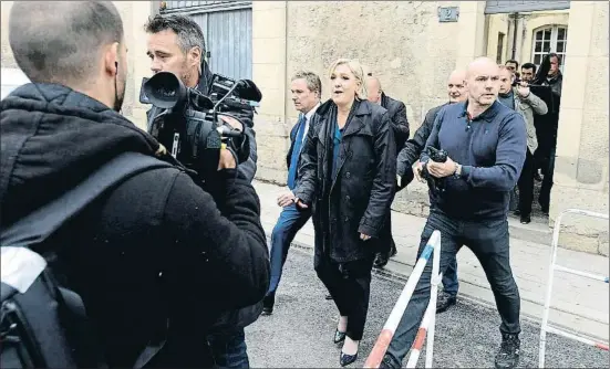  ?? CHARLES PLATIAU / REUTERS ?? Esbroncade­s a Reims. Marine Le Pen va visitar ahir amb Nicolas Dupont-Aignan (a la seva dreta) la catedral de Reims, on va ser esbroncada per un grup de manifestan­ts i va haver d’abandonar el temple per una porta lateral, envoltada de guardaespa­tlles