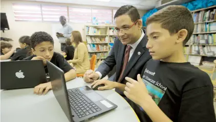  ??  ?? El presidente de la UPR, Uroyoán Walker, y el estudiante Gabriel Ocasio, trabajan en un ejercicio de MineCraft.