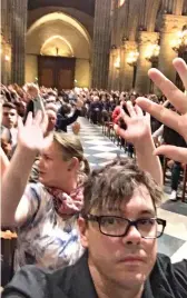  ??  ?? Hands raised: Tourists in Notre Dame