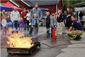  ?? Bild: MÅRTEN SAMUELSON ?? POPULÄRT. Att släcka bränder med spruta var populärt. Här är det Jamie Brodén från Skällinge som testar under överinseen­de av brandman Lars Gustafsson (längst till höger).