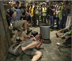  ?? ELSON LI — HK01VIA AP ?? A man hits a suspected attacker after an incident broke out outside a Hong Kong mall on Sunday when the knife-wielding man slashed several people and bit off part of the ear of a local pro-democracy politician.