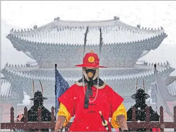  ?? Ahn Young-joon Associated Press ?? AN IMPERIAL guard wears a mask in Seoul outside the Gyeongbok Palace, the main royal palace during the Joseon Dynasty. South Korea has seen at least 30 cases of the novel coronaviru­s that began in Wuhan, China.
