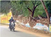  ??  ?? A motorist passes near the debris of the Lingampall­y reservoir wall that collapsed on Wednesday night. —