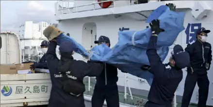  ?? Kyodo News via Associated Press ?? Members of the Japanese Coast Guard carry debris that is believed to be from the crashed U.S. military Osprey aircraft on Monday at a port in Yakushima, Japan.