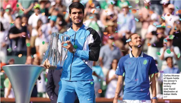  ?? AFP ?? Carlos Alcaraz of Spain holds his winner’s trophy after victory over Daniil Medvedev at Indian Wells