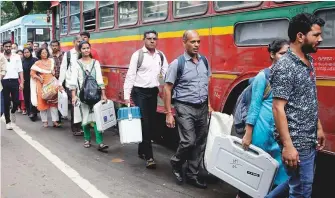  ?? ANI ?? Poll officials make their way to polling stations in Mumbai yesterday.