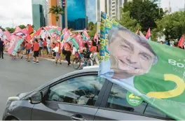  ?? EVARISTO SA/GETTY-AFP ?? Supporters of Brazilian President Jair Bolsonaro drive Saturday past a rally for runoff election opponent former President Luiz Inacio Lula da Silva in Brasilia.