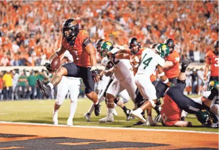  ?? SARAH PHIPPS/THE OKLAHOMAN ?? Oklahoma State's Jaylen Warren rushed for 128 yards and two touchdowns on 37 carries in the Cowboys' 24-14 win over Baylor on Saturday night at Boone Pickens Stadium.
