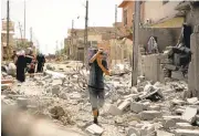  ?? MAYA ALLERUZZO/ASSOCIATED PRESS ?? A boy carries belongings through the rubble as he flees violence in western Mosul, Iraq, on May 15. Iraqi forces are starting an offensive against an ISIS stronghold in the region.