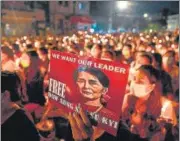  ?? AFP ?? A candleligh­t vigil on March 13, where a protester holds a poster with an image of leader Aung San Suu Kyi in Yangon.