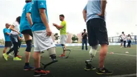  ??  ?? Heinrich Popow (middle) trains amputees to walk and run in the right way with prostheses.