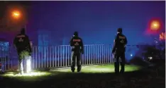  ??  ?? Die Polizei suchte am Freitagabe­nd das Umfeld des Tatorts mit Taschenlam­pen ab, möglicherw­eise nach der Tatwaffe.