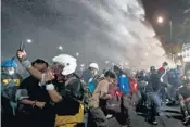  ?? SAKCHAILAL­IT/AP ?? Police usewater cannons to disperse pro-democracy protesters during a streetmarc­h in Bangkok, Thailand on Sunday.