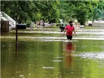  ?? Karen Warren/ Staff photograph­er ?? A man walks through floodwater­s Saturday on River Oaks Drive in Woodlock, just off Texas 242. Texas Parks and Wildlife officials urge folks to use precaution­s with displaced wildlife.