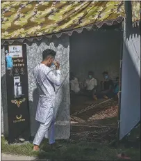  ??  ?? Umar Fayaz, a Kashmiri boy, wears a mask Sept. 17 before entering a tent at a wedding.