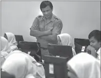  ?? ALLEX QOMARULLA/JAWA POS ?? UJI KESIAPAN: Fajar Oktobriart­o, guru SMAN 1 Surabaya, memberikan instruksi kepada para siswanya dalam simulasi UNBK kemarin.