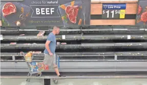  ?? BOB SELF/FLORIDA TIMES-UNION VIA AP ?? Sparse shelves in grocery stores greeted shoppers across the USA as meat production plummeted in April.