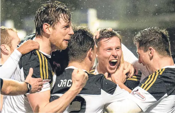  ?? Picture: SNS Group. ?? Simon Church, centre, is mobbed by jubilant team-mates after heading home the Dons’ winner against Partick Thistle.