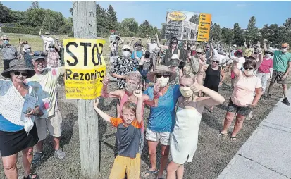  ?? CLIFFORD SKARSTEDT EXAMINER ?? More than 100 residents of the neighbourh­ood gather Tuesday to show their opposition to rezoning for a seven-storey apartment on Armour Road at Cunningham Boulevard. Developer Parkview Homes is proposing a building with 76 market-rent apartments.