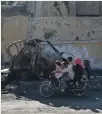  ??  ?? A family rides through Raqqa, Syria, after it was liberated from ISIS this year