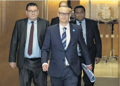  ?? PHOTO: THE NEW ZEALAND HERALD ?? Ending the distractio­n . . . David Clark, flanked by colleagues Grant Robertson (left) and Kris Faafoi, arrives at Thursday’s press conference to announce his resignatio­n as Health Minister.