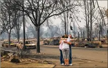  ?? JIM WILSON / THE NEW YORK TIMES ?? Tina and Art Anaya hug Lisa Coats on a street Monday in the Coffey Park subdivisio­n, where they all lost their homes to a wildfire, in Santa Rosa, Calif.