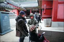  ?? XINHUA ?? Chinese tourists use a map at Hwaseong Fortress in Suwon city, South Korea.