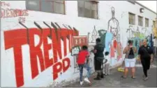  ?? GREGG SLABODA — THE TRENTONIAN ?? The Trenton Police Department’s YouthStat program members paint murals on the evidence building on Tuesday evening, Aug. 22, 2017.