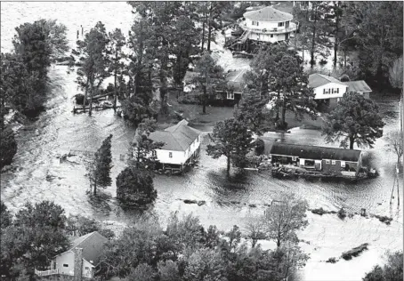  ?? STEVE HELBER/AP ?? Floodwater­s surround homes along the Neuse River on Saturday in New Bern, N.C. The slow-moving storm system has drenched the Carolinas.