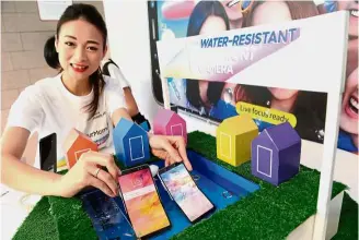  ?? — Photos: Samsung ?? A model showing that dipping the smartphone in water isn’t fatal as the A8+ meets the IP68 standard for water resistance.