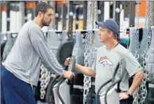  ?? By Eric Bakke, AP ?? New guy: Peyton Manning, right, chats with tight end Jacob Tamme on Monday, when he lifted weights and led passing drills with the Broncos.