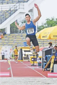  ??  ?? Paralympic champion Abdul Latiff soars to victory in the long jump.