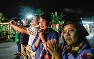  ?? LAUREN DECICCA / GETTY IMAGES ?? Onlookers watch and cheer as ambulances deliver boys rescued from a cave in northern Thailand to a hospital in Chiang Rai on Sunday after they were transporte­d by helicopter­s. Four boys have been taken out of the cave but eight and their coach remain.