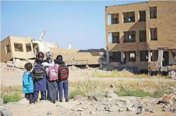  ?? AFP ?? Yemeni girls look at their school that was damaged by an Al Houthi missile in Taiz city. Trump administra­tion is removing Obama-era restrictio­ns to boost Saudi and UAE efforts to defeat the rebels.