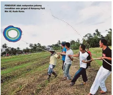  ??  ?? PENDUDUK tidak melepaskan peluang menaikkan wau gergasi di Kampung Parit Mat Ali, Kuala Kurau.