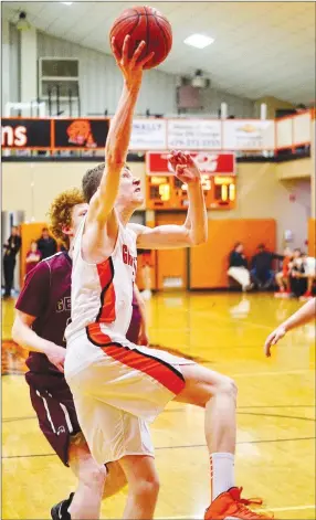  ?? Westside Eagle Observer/RANDY MOLL ?? With Casey Bates behind him, Gravette’s Tristan Batie goes up for a shot under the basket during the Jan. 29 game between Gentry and Gravette at Lion Field House.