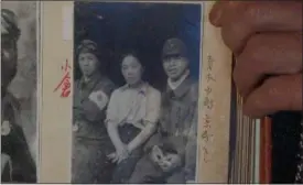  ?? THE ASSOCIATED PRESS ?? In this July 19image taken from Associated Press Television video, Akihisa Torihama shows a 1945photog­raph of his grandmothe­r Tome Torihama, center, with Tokko pilots in Chiran in Kagoshima Prefecture, south west of Japan. Chiran served as a takeoff...