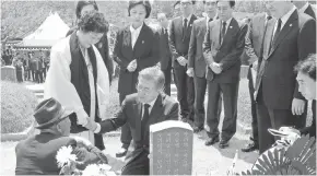  ?? KIM MIN- HEE, AFP/ GETTY IMAGES ?? South Korean President Moon Jae- in, center, consoles family members during the annual Democratic uprising ceremony Thursday at the Gwangju National Cemetery, in the southweste­rn city of Gwangju. This year marks the 37th anniversar­y of a pro- democracy...