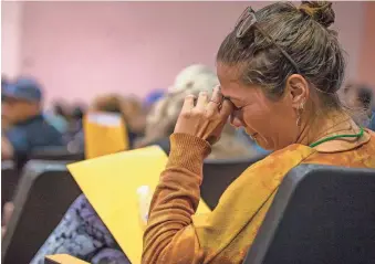  ?? MONICA D. SPENCER/THE REPUBLIC ?? Resident Esin Pirkul cries while listening to Tunnel Fire updates during a community meeting held at Sinagua Middle School in Flagstaff on Saturday.