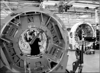  ?? BLOOMBERG ?? An employee works on the gantry of a Somatom computeriz­ed tomography (CT) scanner on the assembly line at the Siemens Healthinee­rs factory in Forchheim, Germany, in July.