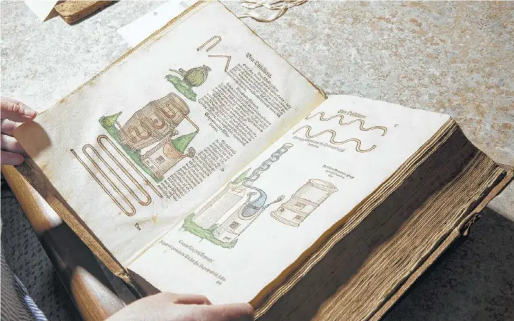  ?? Photos by Jenn Ackerman / New York Times ?? This 16th-century book at the Wangenstee­n Historical Library at the University of Minnesota explains how to build and operate a still.