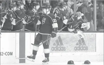  ?? Robert Gauthier Los Angeles Times ?? DUSTIN BROWN wears one of the hats thrown at him by fans after he scored a hat trick in the second period at Staples Center. His fourth goal didn’t get him any headgear but won the game for the Kings in overtime.