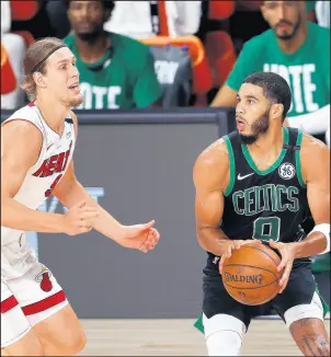  ?? MIKE EHRMANN/GETTY ?? Celtics’ Jayson Tatum drives the ball against the Heat’s Kelly Olynyk in Game 5 of the Eastern Conference finals on Friday in Lake Buena Vista, Florida.