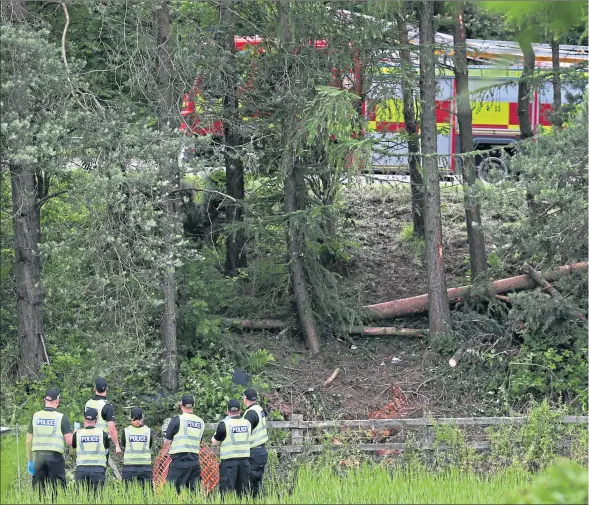  ??  ?? Police officers at the scene of crash tragedy near the M9 at Stirling on July 9, 2015, four days after the accident was first reported